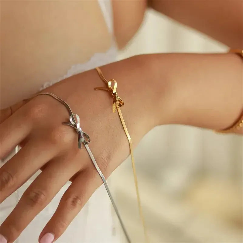 Bow Knot gold and silver necklace displayed on wrist of the hand