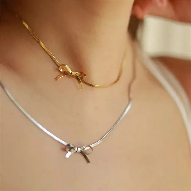 Person wearing a silver and gold bow know choker style necklace