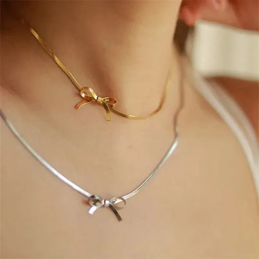 Person wearing a silver and gold bow know choker style necklace