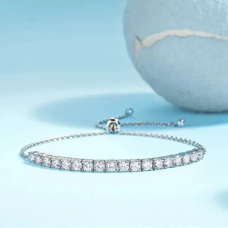 Sterling Silver Chain Bracelet with light blue background with  a blue tennis ball in the background