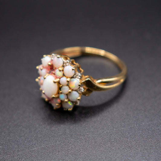 Gold ring with opal stones on a dark gray background